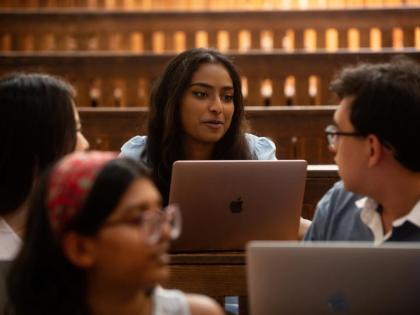 4 students in a lecture on laptops. 