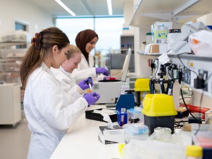 3 students in a lab. They are working with different technical equipment.